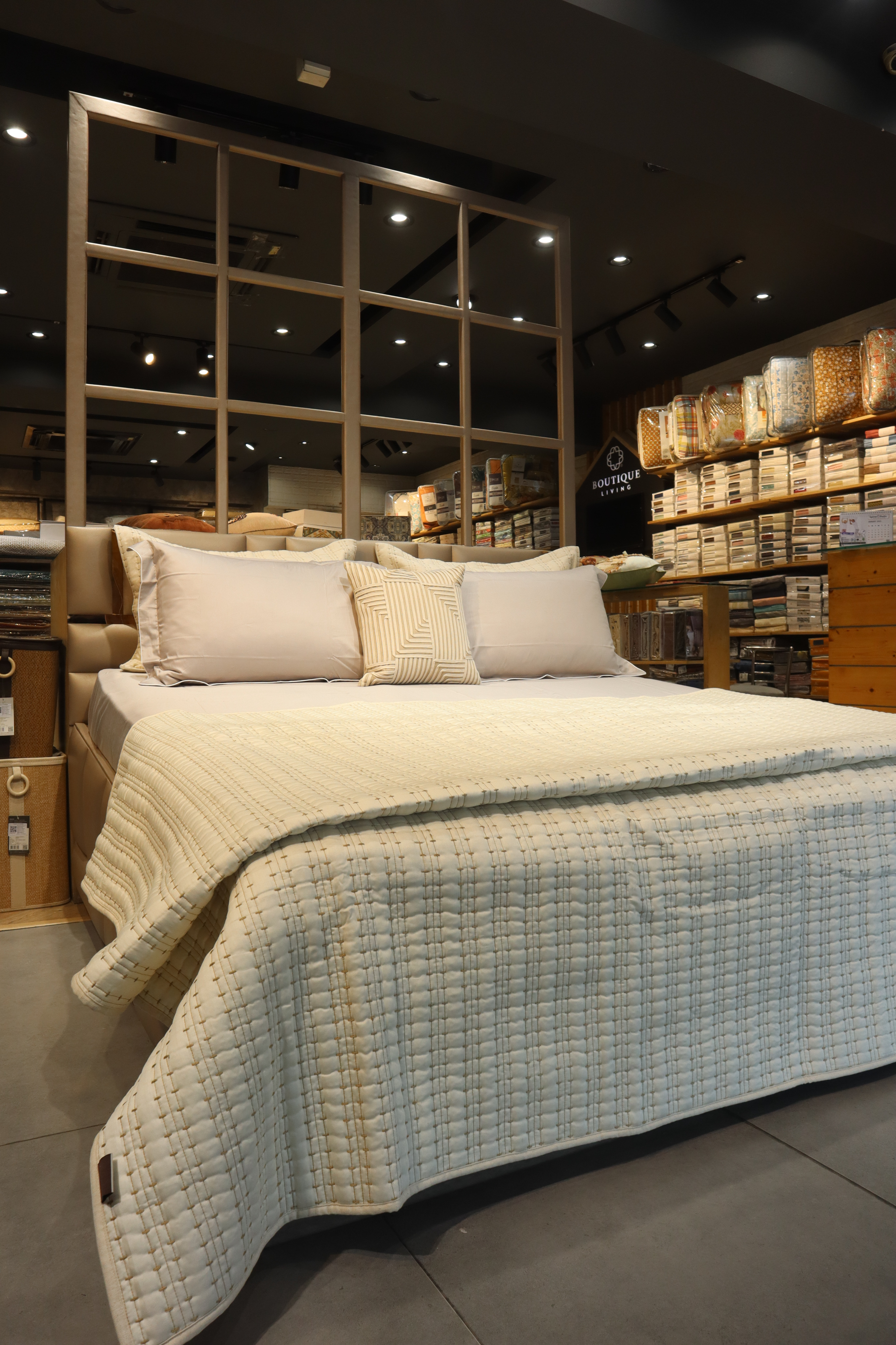 Luxury cream quilted bedspread with pillows in a fabric showroom