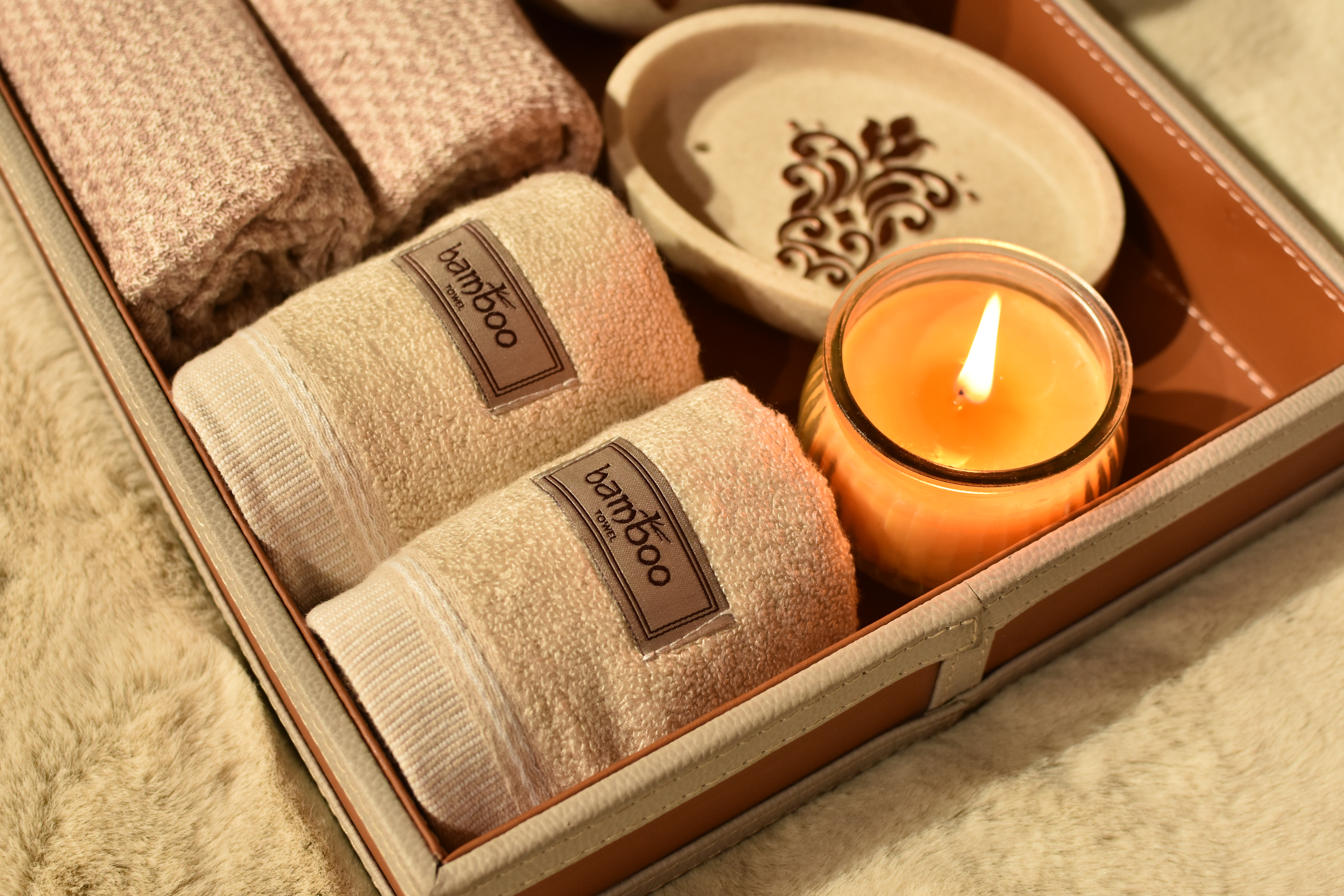 Spa tray with bamboo towels, candle, and ceramic dish
