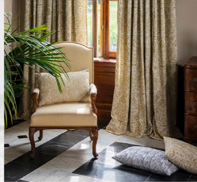 Beige armchair with gold curtains and checkered floor
